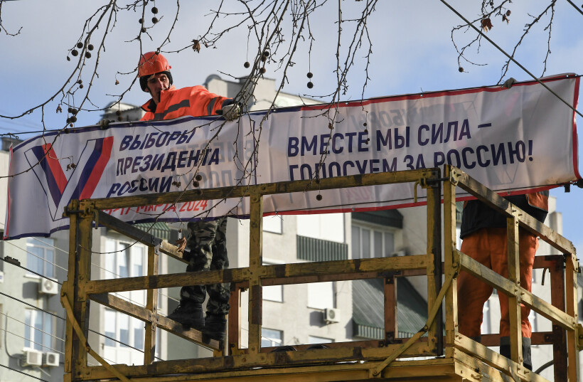 Рабочие устанавливают предвыборный баннер на одной из улиц Симферополя. Фото