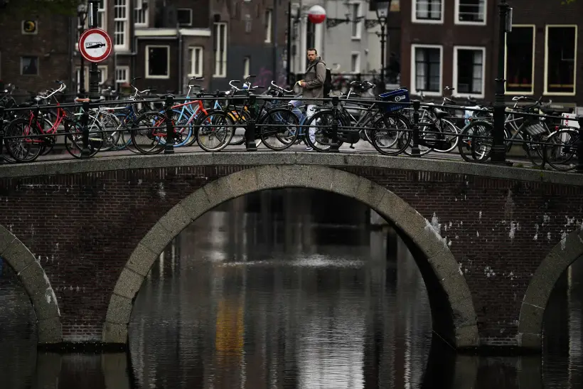 Велопарковка на мосту через канал в Амстердаме. Фото