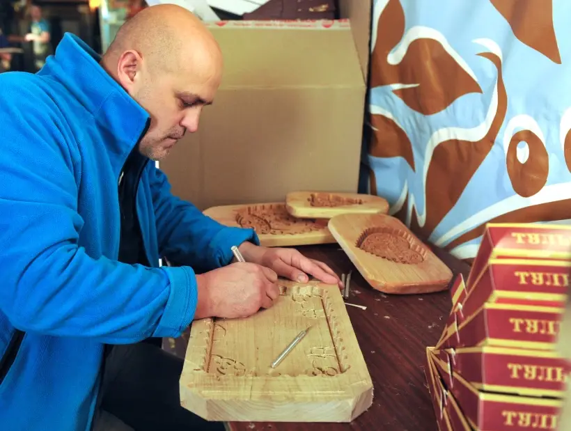 Художник вырезает форму для выпекания тульского пряника. Фото